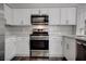 Modern kitchen featuring stainless appliances, white cabinets and stone countertops at 7905 Idledale Ct # 102, Las Vegas, NV 89145