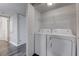 Convenient laundry room featuring a side by side washer and dryer and an overhead rack for storage at 7905 Idledale Ct # 102, Las Vegas, NV 89145