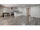 Open floor plan living room with wood flooring, breakfast bar and stainless refrigerator at 7905 Idledale Ct # 102, Las Vegas, NV 89145