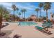 Relaxing pool area with lounge chairs, clear blue water, and lush palm trees in a well-maintained community at 7905 Idledale Ct # 102, Las Vegas, NV 89145