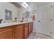 Well-lit bathroom featuring dual sinks, wood cabinets, and decorative mirrors at 8137 Cape Flattery Ave, Las Vegas, NV 89147