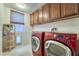 Functional laundry room with a red washer and dryer set and storage cabinets at 8137 Cape Flattery Ave, Las Vegas, NV 89147