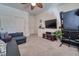 Living room featuring neutral carpeting, a dark sofa, and an entertainment center at 8137 Cape Flattery Ave, Las Vegas, NV 89147