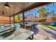 Inviting outdoor patio with dining and seating areas, overlooking the sparkling pool and lush backyard at 8137 Cape Flattery Ave, Las Vegas, NV 89147
