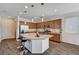 Bright kitchen boasts stainless steel appliances, granite counters, island with bar seating, and wood-look flooring at 8164 Golden Cholla Ave, Las Vegas, NV 89179