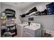 Organized laundry room with washer, dryer, and shelving for efficient storage and convenience at 8164 Golden Cholla Ave, Las Vegas, NV 89179