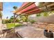 Private backyard with a pergola, lush landscaping, a stone patio, and a cozy fire pit at 8317 Fritzen Ave, Las Vegas, NV 89131
