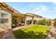 Lush backyard featuring a covered patio, green lawn, and serene landscaping for outdoor enjoyment at 8317 Fritzen Ave, Las Vegas, NV 89131