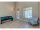 Bright entryway featuring tile floors, a bench with turquoise pillows, and a cozy chair near the window at 9469 Coral Shine Ct, Las Vegas, NV 89123