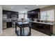 Modern kitchen featuring stainless steel appliances, dark wood cabinets, white countertops, and tile backsplash at 9469 Coral Shine Ct, Las Vegas, NV 89123