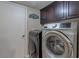 Convenient laundry room featuring a modern washer and dryer set and ample cabinet space at 9469 Coral Shine Ct, Las Vegas, NV 89123