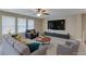 Relaxing living room featuring neutral colors, a ceiling fan, plush seating, and a large television at 9469 Coral Shine Ct, Las Vegas, NV 89123