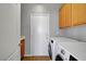 Laundry room showcasing washer, dryer, and wooden cabinets for supplies at 10135 Diving Duck Ave, Las Vegas, NV 89117