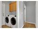 Laundry room with washer, dryer, and wooden cabinets for ample storage space at 10135 Diving Duck Ave, Las Vegas, NV 89117