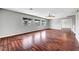 Spacious living room with hardwood floors, fan, and multiple windows for natural light at 10135 Diving Duck Ave, Las Vegas, NV 89117