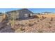 The backyard is landscaped with low water desert landscaping and the home's exterior painted gray at 1048 Forrest Falcon Dr, Henderson, NV 89011