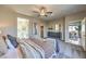 Spacious bedroom with soft carpet, ceiling fan, and views to the outdoor living space and en-suite bathroom at 1048 Forrest Falcon Dr, Henderson, NV 89011