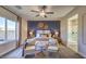 Stylishly furnished main bedroom featuring a decorative accent wall, soft carpet, and comfortable seating area at 1048 Forrest Falcon Dr, Henderson, NV 89011