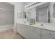 Bathroom featuring dual sinks, bright lighting and mirror reflecting the shower at 10525 Pine Glen Ave # 206, Las Vegas, NV 89144