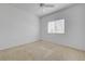 Bright bedroom features neutral carpet, a ceiling fan, and a window letting in natural light at 10525 Pine Glen Ave # 206, Las Vegas, NV 89144