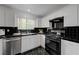 Modern kitchen featuring white cabinets, stainless steel appliances, and sleek black tile backsplash at 10525 Pine Glen Ave # 206, Las Vegas, NV 89144