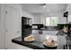 Eat-in kitchen with black tile countertops, stainless steel dishwasher, and white cabinets at 10525 Pine Glen Ave # 206, Las Vegas, NV 89144