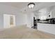 Bright living room flows into kitchen, featuring neutral carpet and white walls for a modern, airy feel at 10525 Pine Glen Ave # 206, Las Vegas, NV 89144