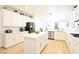 Bright kitchen featuring white cabinets, a center island, stainless steel appliances and hardwood floors at 10591 Haywood Dr, Las Vegas, NV 89135