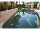 Sparkling swimming pool with tiled edge, complemented by mature landscaping and a relaxing sunbathing area at 10591 Haywood Dr, Las Vegas, NV 89135