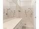 A bright bathroom featuring a walk-in shower with dual shower heads, grab bars, and a marble-look surround at 10712 Back Plains Dr, Las Vegas, NV 89134
