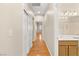 Hallway with hardwood floors, leading to a bathroom with double doors and natural light at 10712 Back Plains Dr, Las Vegas, NV 89134