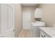 Bright laundry room with a white washer, dryer, and cabinets for storage at 10712 Back Plains Dr, Las Vegas, NV 89134