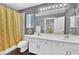Bright bathroom featuring a double sink vanity and shower/tub combo with gold curtain at 10902 Fintry Hills St, Las Vegas, NV 89141