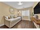 Cozy bedroom with a daybed, stylish round mirror, and modern television at 10902 Fintry Hills St, Las Vegas, NV 89141