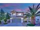 Charming two-story home featuring a well-manicured lawn, a two-car garage, and mature trees at 10902 Fintry Hills St, Las Vegas, NV 89141