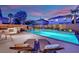 Outdoor pool featuring water features, custom patio, and an outdoor kitchen area create a backyard oasis at 10902 Fintry Hills St, Las Vegas, NV 89141