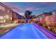 Inviting outdoor pool area with an outdoor kitchen, comfortable lounge chairs, and lush landscaping at 10902 Fintry Hills St, Las Vegas, NV 89141