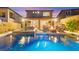 Inviting backyard pool with an outdoor kitchen and lounge area for relaxation and entertaining at twilight at 12430 Foxtail Run Ave, Las Vegas, NV 89138
