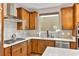 Kitchen with modern appliances, neutral countertops and backsplash, and wood-toned cabinets at 12430 Foxtail Run Ave, Las Vegas, NV 89138