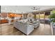 Open living room featuring a large sectional sofa, hardwood floors, and sliding glass doors to the backyard at 12430 Foxtail Run Ave, Las Vegas, NV 89138