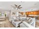 Spacious living room features a large sectional sofa, fan, and view of the kitchen and dining area at 12430 Foxtail Run Ave, Las Vegas, NV 89138