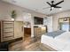 Calm main bedroom featuring wood-like floors, modern furniture, a ceiling fan, and an en-suite bathroom at 12430 Foxtail Run Ave, Las Vegas, NV 89138