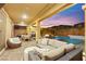 An inviting covered outdoor patio with stylish furniture, a grill, fire pit, and pool view, perfect for entertaining at 12430 Foxtail Run Ave, Las Vegas, NV 89138