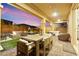 An outdoor dining table and seating area extend from the home to the pool, and a built-in fire pit area at 12430 Foxtail Run Ave, Las Vegas, NV 89138