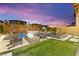 This stunning backyard boasts a pool, spa, fire pit, and lush turf, perfect for outdoor entertaining and relaxation at 12430 Foxtail Run Ave, Las Vegas, NV 89138