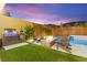 The backyard features a pool with outdoor kitchen, fire pit and lounge chairs for ultimate relaxation and enjoyment at 12430 Foxtail Run Ave, Las Vegas, NV 89138