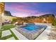 A beautifully designed pool with a spa, fire pit, built-in barbecue, and a basketball hoop offers a backyard paradise at 12430 Foxtail Run Ave, Las Vegas, NV 89138