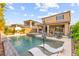 A stunning pool area with waterfall feature, lounge chairs, spa, fire pit and outdoor living space at 12430 Foxtail Run Ave, Las Vegas, NV 89138