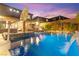 Inviting backyard with a private pool, waterfall feature, lounge chairs, and a built-in basketball hoop at 12430 Foxtail Run Ave, Las Vegas, NV 89138