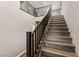 Modern staircase with wooden steps and a sleek black railing at 12430 Foxtail Run Ave, Las Vegas, NV 89138
